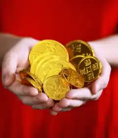 person holding gold-colored ching coins